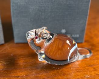 This lot features a set of two Steuben Crystal beaver figurines with garnet eyes, designed by Lloyd Atkins for Steuben in 1975. Comes with a pair of Steuben boxes. 
