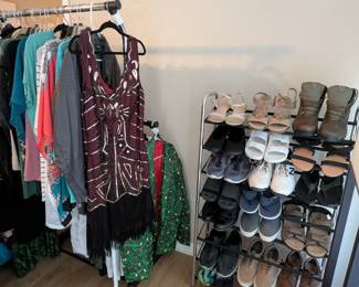 Women's & Men's Clothing and Shoes
Clothing rack featuring assorted dresses, tops, and casual wear alongside 8-tier shoe organizer with multiple pairs of sandals, sneakers, boots, and heels. Includes statement pieces like sequined burgundy dress with fringe, green printed dresses, and variety of footwear. Women's shoes size 11-12, women's clothing, closet organization, shoe rack, clothing lot, wardrobe collection.