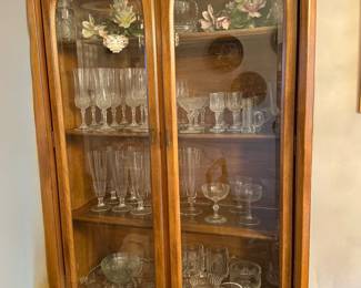 One of two dining room hutches with two Capodimonte porcelain pieces, stemware, and other crystal.