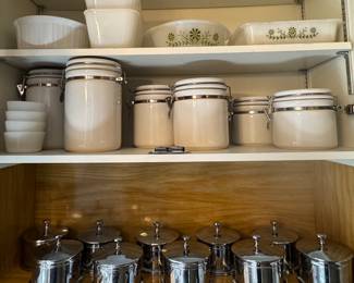 Pyrex cookware, two sets of white canisters, metal storage containers.