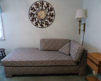 Daybed/chaise, wall clock, brass wall lamp, wicker side cabinet