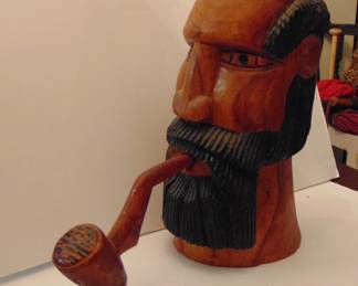 Carved head with pipe