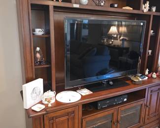Entertainment center with miscellaneous decor, electronics & large TV