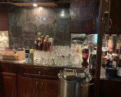 Basement filled with glassware, novelties, pots, pictures, desk, and bedroom furniture