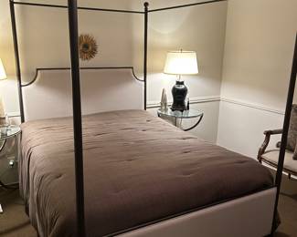 Queen size 4 poster metal bed with upholstered headboard and footboard.