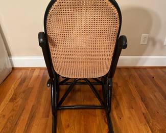 E56 - $30. Black painted caned rocking chair.