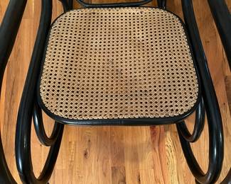 E56 - $30. Black painted caned rocking chair.
