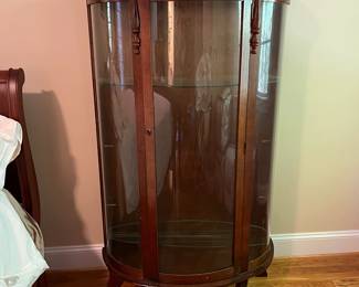 E44 - $100. Bow front curio with 3 glass shelves. Measures 34.5" wide x 14.25" deep x 57" tall.