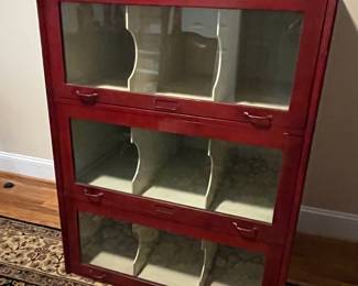 E25 - $650. Antique Cabinet. One Piece. Barrister Style Glass Doors that pull down to protect merchandise. I believe this was also from an old store. Measures 38.25" wide x 26.5" deep x 49" tall.
