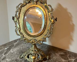 E73 - $40. Heavy Brass Table Mirror. Single sided mirror but does adjust up & down. Measures 11.5" x 17.5" tall.