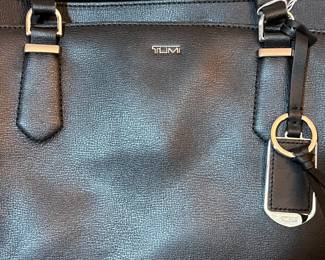 E76 - $85. TUMI Sinclair Tote Black Leather. Measures 20" x 11.5" tall (without handles) x 6" wide.