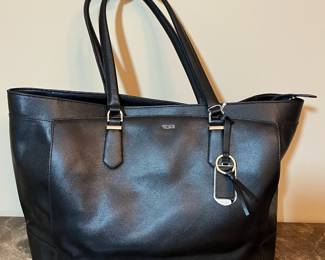 E76 - $85. TUMI Sinclair Tote Black Leather. Measures 20" x 11.5" tall (without handles) x 6" wide.