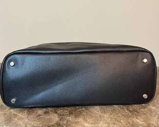 E76 - $85. TUMI Sinclair Tote Black Leather. Measures 20" x 11.5" tall (without handles) x 6" wide.