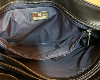E76 - $85. TUMI Sinclair Tote Black Leather. Measures 20" x 11.5" tall (without handles) x 6" wide.
