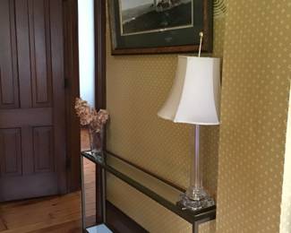 Modern glass and metal console table, lamp, framed wall art