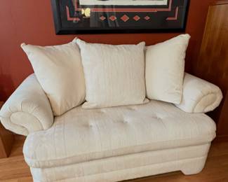 Off White and Pastel upholstered loveseat with rolled arms and tufted cushions. (Excellent Condition)