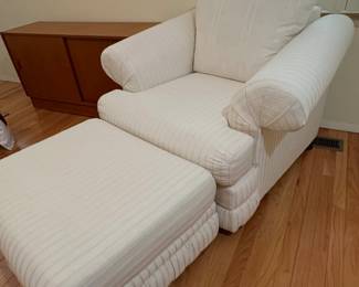 Large upholstered armchair with a matching ottoman.