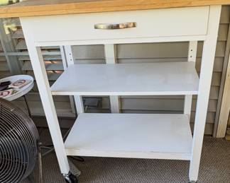 TRINITY kitchen cart with drawers and a wood top.