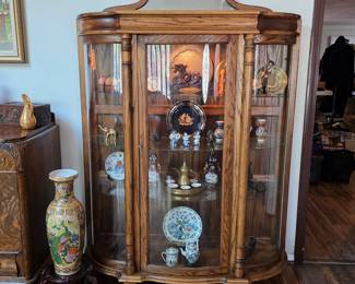 Gorgeous antique lighted curio cabinet with antiques and collectibles