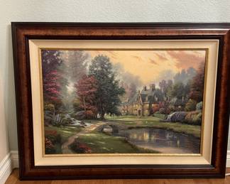 Lot #123 A framed and matted landscape hand colored giclee print on canvas painting depicting a cottage by a pond with trees and a stone bridge. The frame is dark brown with a gold inner edge and beige matting. The back of the artwork shows a pencil sketch with a signature. There is a label indicating 'Genuine Thomas Kinkade Studios' and 'Standard Numbered' limited edition.
Art Field 23 1/4โ x 34 1/4โ
Overall 34 3/4โ x 46 3/4โ