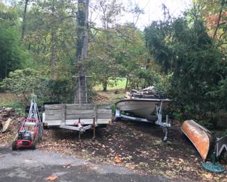 Camp Out aluminum trailer with wood kit on floor and sides, Glastron boat with trailer, canoe and paddles, power washer, umbrella stand, folding garden cart