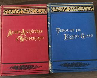 Two antique Lewis Carroll classics — Alice’s Adventures in Wonderland (1893) and Through the Looking-Glass (circa 1891), both illustrated by John Tenniel. Original gilt-decorated red and blue cloth covers. Printed in New York by Macmillan.
