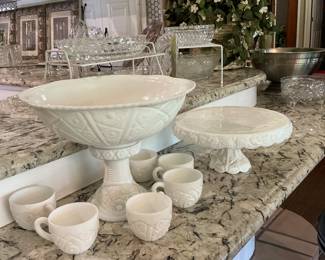 This is a milk, glass punch bowl and stand comes with 24 cups paired off with a white cake plate on a stand