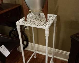Mid-century, modern ice bucket sitting on a little iron white table
