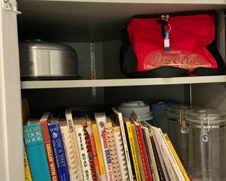 Variety of cookbooks, including Riverroad Tupperware covered cake carrier
