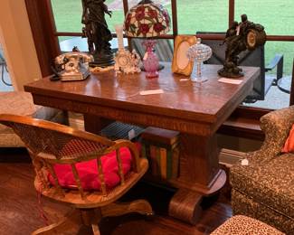 on the desk. There was a Tiffany style lamp two pieces of art deco Silvertone push button phone. The desk is a tiger. Oak can be used as a buffet table a library desk numerous usage. The chair is a roll around Victorian office chair.