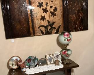 There is a stained glass, hummingbird gone with the wind lamp. The cabinet is mid-century modern variety of books, and a set of book ends.