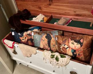 This is a true lane cedar chest filled with cat pillows, true collars, vintage ladies handkerchiefs