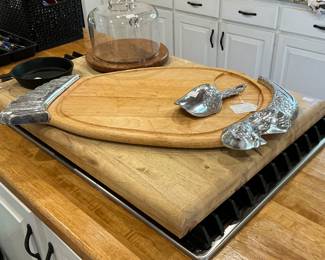 Here you will find a very large cutting board also a turkey cutting board low black iron skillet and a cheese covered tray