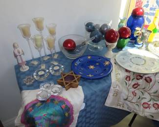 Judaic table, Menorahs, Seder plates, candles, goblets, linens, colored glass pieces, soft toys, artwork.