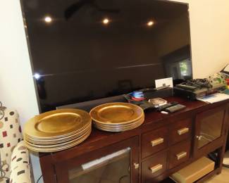 Samsung TV, Vizio sound bar and sub woofer, TV stand, gold chargers.