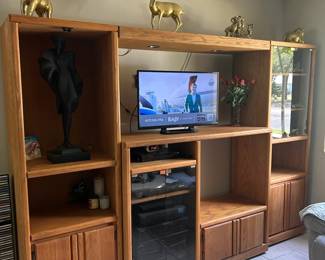 Oak entertainment center with glass cabinet and doored storage