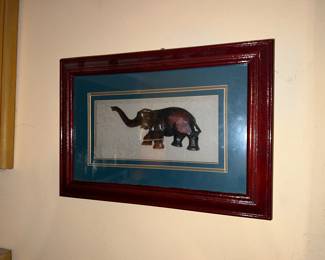framed piece of art featuring a carved wooden elephant
