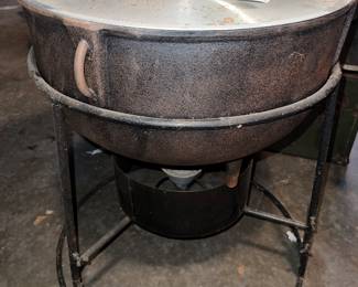 cast iron jambalaya pot with a stand and burner