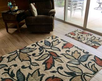 Matching rugs, vintage La-Z-Boy, brass lamp, and unique side table