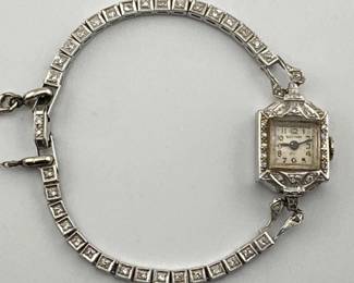 Antique platinum Gotham ladies watch (currently not working) has diamond surround with diamond watch band. Watch is engraved on back and marked 900 Platinum, .100 Iridium; band is marked 10% Irid. Pl. Watch measures approx 5.5"L