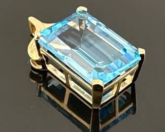 14kt blue topaz pendant. Large emerald cut blue topaz measures 18mm H x 12mm W x 9mm D; 1”drop