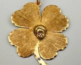 Unusual brushed 14kt gold four leaf clover has raised head in center with diamonds for eyes. Blemish on stem. Measures 1.75"H, 10.69g. Tested as 14kt