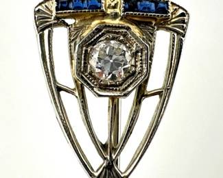 18kt white gold diamond and sapphires stick pin. Marked 18kt, old mine cut diamond in shield shaped setting with two rows of square cut natural sapphires
