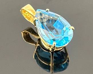 14kt pear shaped blue topaz pendant. Marked 14K on locking clasp; 0.75”drop. Topaz measures 15mm H x 10mm W x 8mm D
