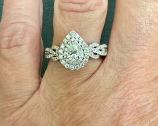 Size 7.5 pear shape diamond ring has diamonds on shoulder and gallery and is set in 14kt white gold