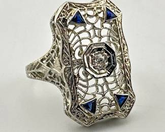 Size 4.5 Art Deco filigree dinner ring has a center diamond with triangular cut sapphires in each corner. The filigree design is similar to a spider's web. It is marked 18kt