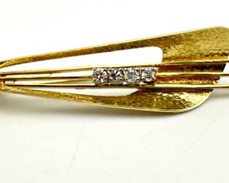 Modernist style brooch has textured surface with four round cut diamonds. It is marked 14kt/Germany; 2"L