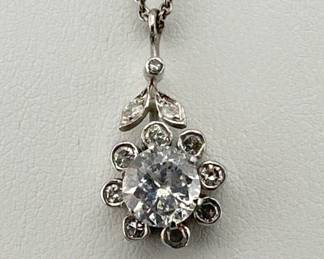 Diamond pendant on 14kt white gold necklace is floral in shape; center one carat diamond. 1.25 ctw., H color, I clarity; 17"L