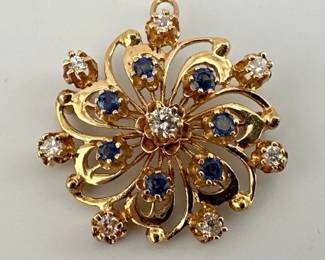 Vintage pinwheel brooch/pendant (with bail) is set with seven diamonds, six natural sapphires and a larger center diamond in 14kt gold; 1.25"Diam, 9.25g. Diamonds total 1/2 carat and sapphires total 1/2 carat