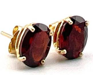 Oval garnet studs set in 14kt gold; 8mm wide